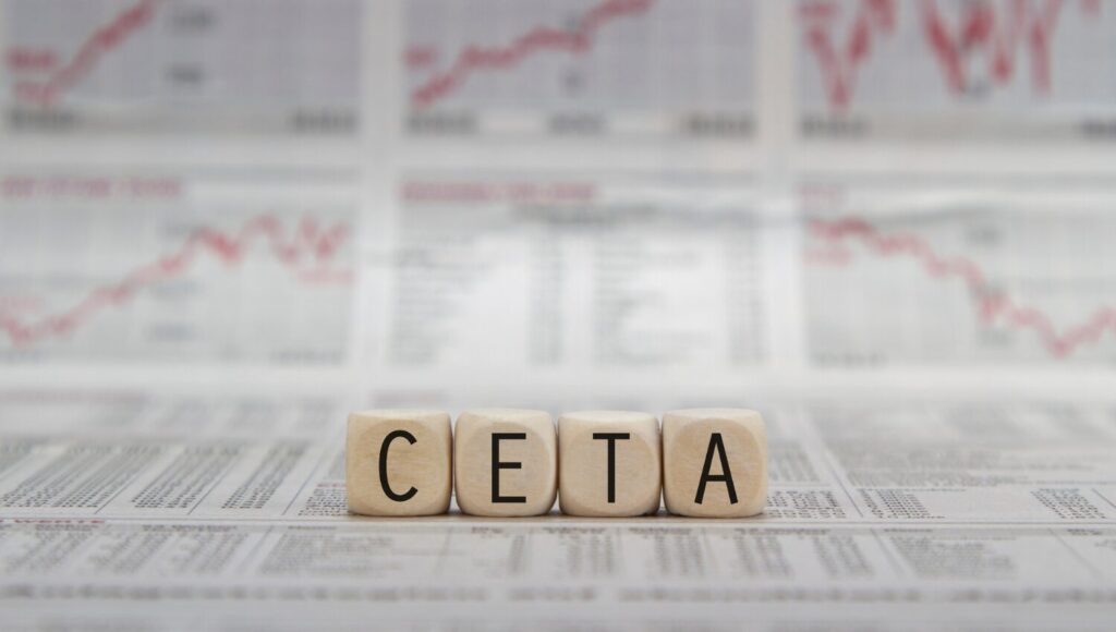 Bokstäverna CETA placerade på ekonomisidor, symboliserar handelsavtal och internationell handel som påverkas av USA:s importtullar.